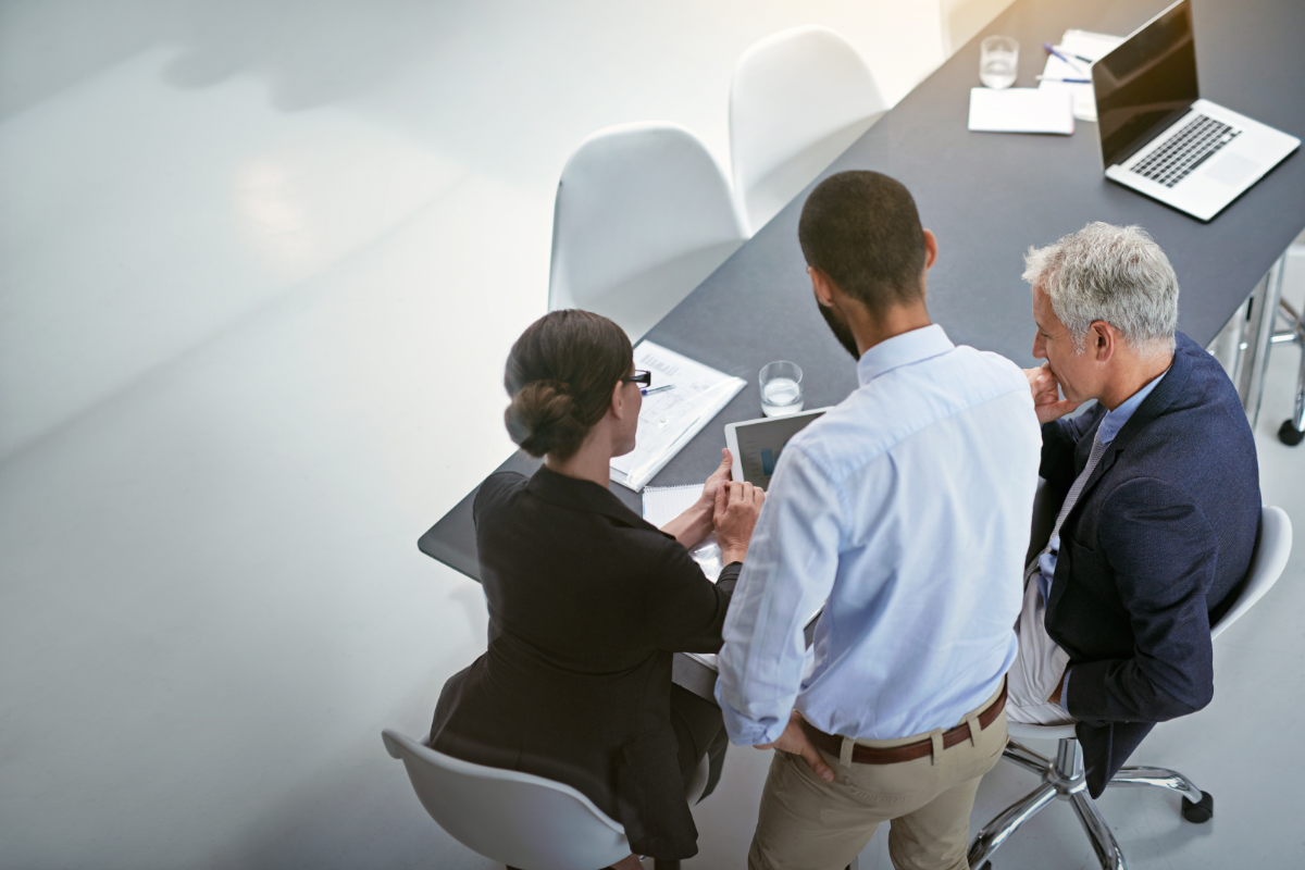 Three people discussing business matters in a corporate environment.